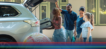 Family loading a vehicle for summer vacation