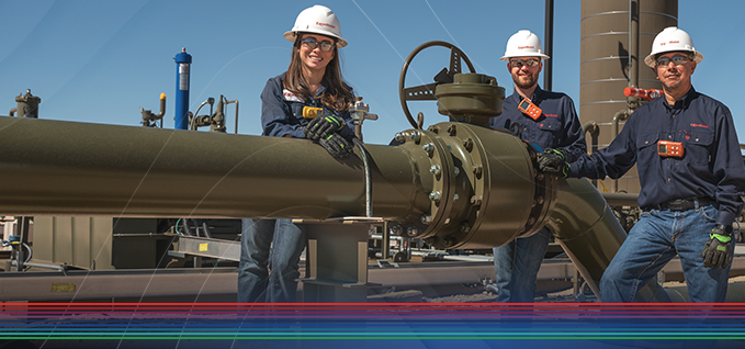 Workers standing next to a pipe