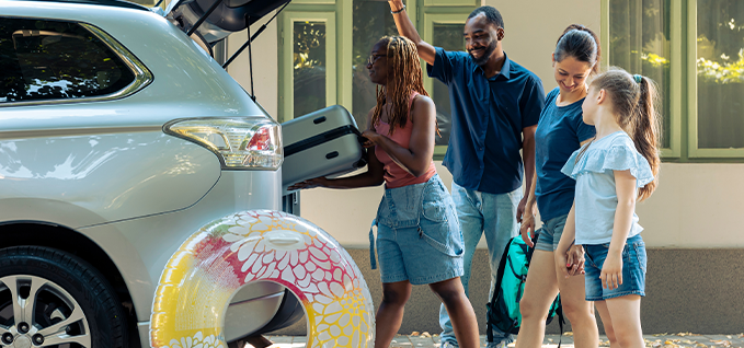 Family loading a vehicle for summer vacation