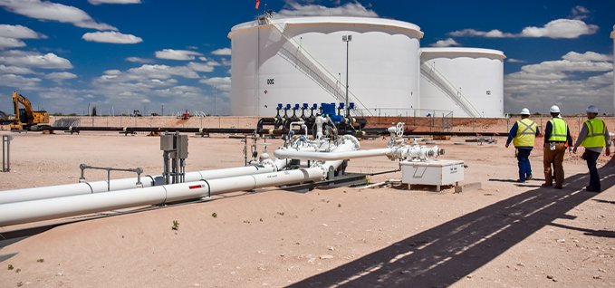 Workers walking toward storage tanks