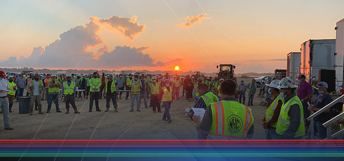 Worksite safety meeting at sunrise