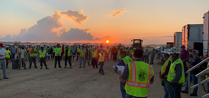 Worksite safety meeting at sunrise