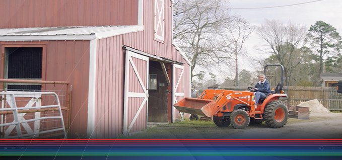 Landowner on a tractor in front of a barn