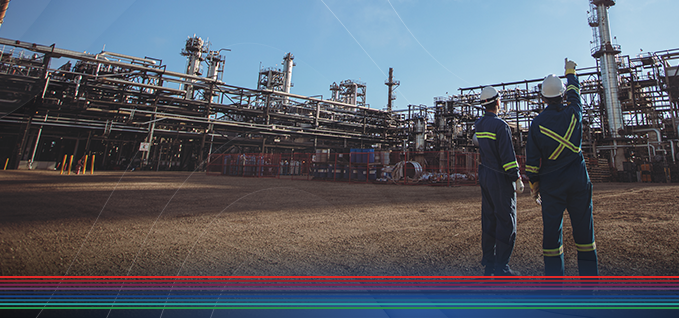 Two workers pointing at pipes in a facility