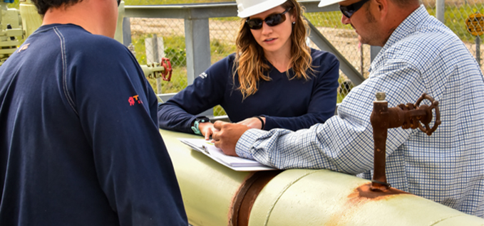 Workers talking beside pipeline