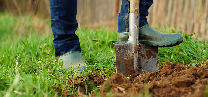 Close up of man's shoes digging with a shovel