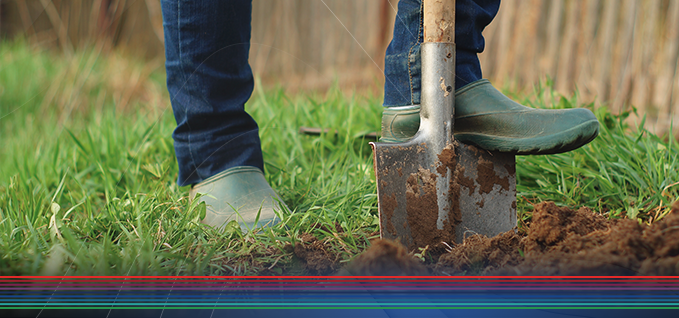 Close up of man's shoes digging with a shovel